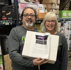 TruStone Financial member and Credit Union Magic Minute™ Loyalty Sweepstakes winner Judy and her husband Tony pose with one of the prizes they grabbed during a 60-second warehouse dash.