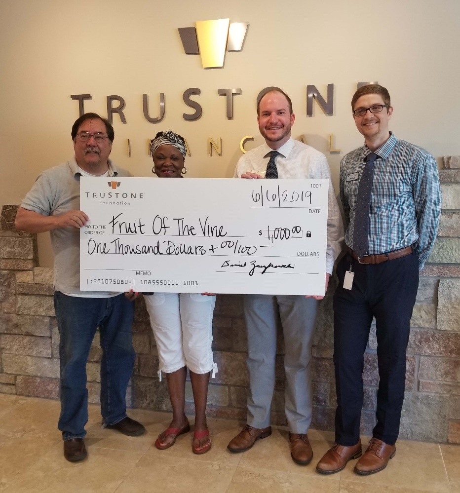 Staff from Fruit of the Vine accepted the $1,000 donation at TruStone Financial’s Burnsville branch.